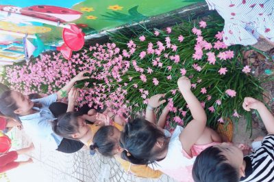 Cô và trẻ cùng chăm sóc hoa